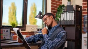 A young man sitting down to observe his side hustle track record for the day.